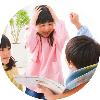 絵本とじゃれあう園児たちの様子