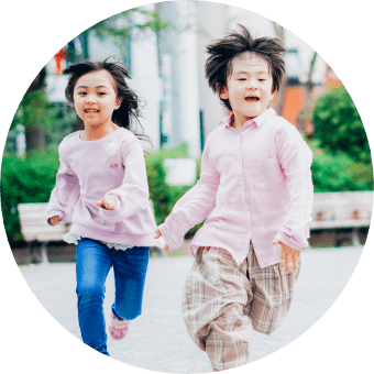 公園走っている笑顔の園児たち